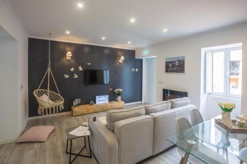 a living room with a couch and a swing at Bicycle Villas - AL in Ponta Delgada