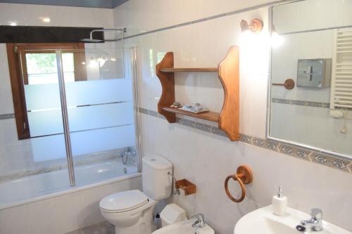 Baño blanco con aseo y lavamanos en Amaicha Apartamentos Rurales, en Ribadesella