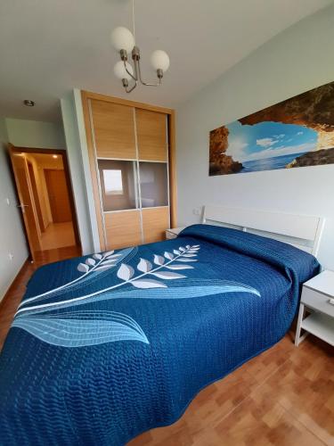 1 dormitorio con edredón azul en la cama en Lugomar, en Barreiros