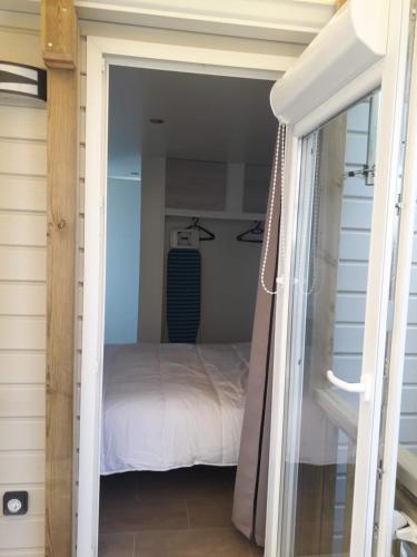 une porte menant à une chambre avec un lit dans l'établissement mobil home neuf 2 chambres 6 personnes Saint Aygulf plage, à Fréjus