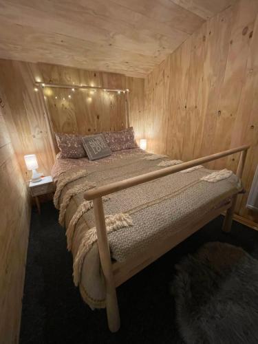 a bedroom with a bed in a wooden cabin at Keepers Cottage in Ipswich