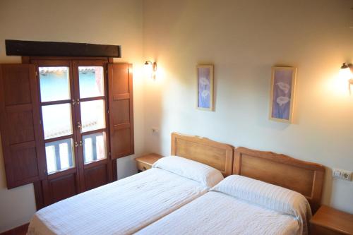 a bedroom with two beds and a window at Amaicha Apartamentos Rurales in Ribadesella