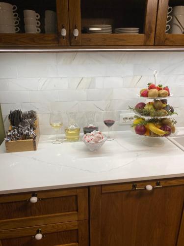 a kitchen counter with a plate of fruit and wine glasses at Guesthouse Tershana in Peshkopi