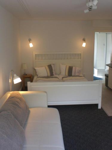 a bedroom with a large white bed and a couch at Zur Weide in Boltenhagen