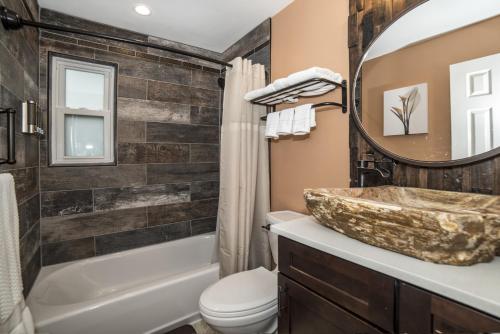 a bathroom with a sink and a toilet and a mirror at Gulfport Beach Vacation Rental in St Petersburg