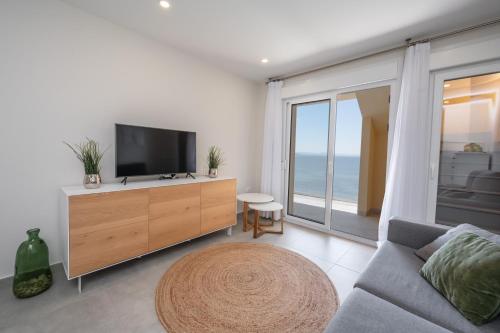 Il comprend un salon doté d'une télévision à écran plat et d'un canapé. dans l'établissement WONDER2SEA - Style & Comfort & Beach - LA MANGA, à La Manga del Mar Meno
