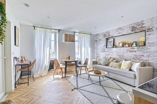 un salon avec un canapé et un mur de briques dans l'établissement # Ethnic Suite # Parking Gratuit # calme # Cosy, à Mulhouse