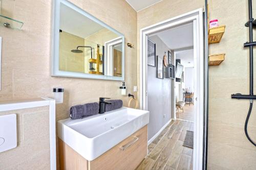 une salle de bain avec un lavabo et un miroir dans l'établissement # Ethnic Suite # Parking Gratuit # calme # Cosy, à Mulhouse