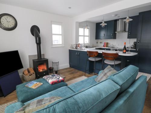a living room with a blue couch and a kitchen at 126 Main Street in Keighley