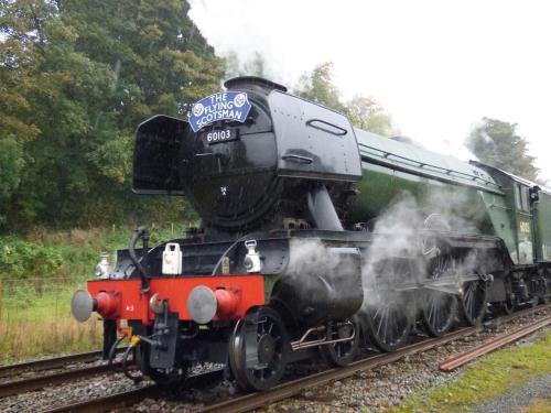 a steam engine train is on the tracks at 126 Main Street in Keighley