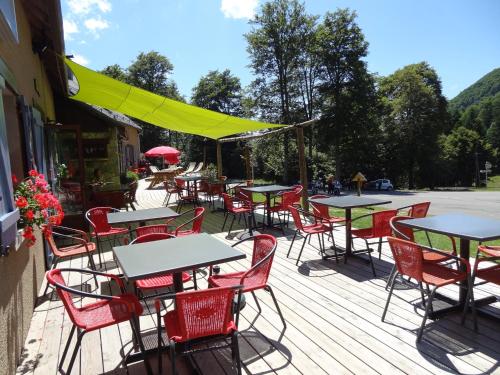 un montón de mesas y sillas en una cubierta en Auberge La Soulan, en Boutx