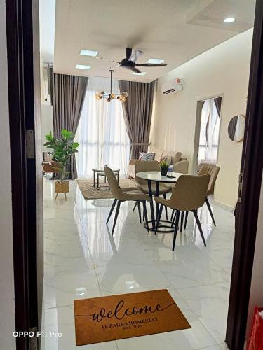 a dining room and living room with a table and chairs at Al Zahra Homestay by Troika Kota Bharu in Kota Bharu