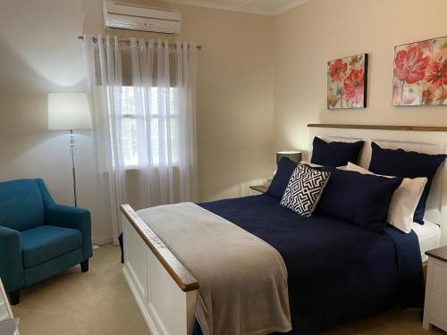 a bedroom with a blue bed and a blue chair at Hideaway on Hume in Boonah