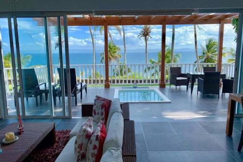 a living room with a pool and a view of the ocean at Apartamento Condominio Vista Mare Samana in Santa Bárbara de Samaná
