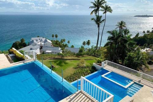 an aerial view of a house with a swimming pool and the ocean at Apartamento Condominio Vista Mare Samana in Santa Bárbara de Samaná