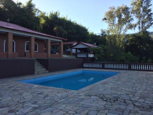 a swimming pool in front of a house at Chácara Paraíso de Itamonte MG in Itamonte