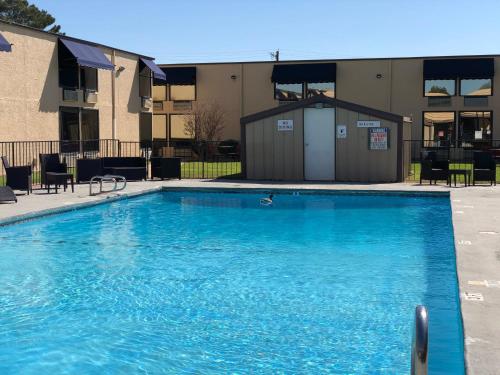 a large blue swimming pool in front of a building at Hotel 34FIFTY in Abilene