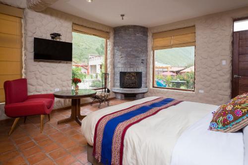 1 dormitorio con 1 cama y chimenea en Intiterra Apart Hotel Villas en Urubamba