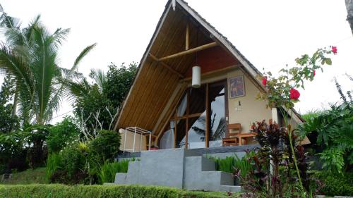 a small house with stairs leading to the door at Padi Bali Jatiluwih in Tabanan