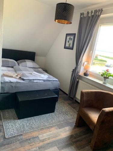 フーズムにあるPrivates Ferienzimmer an der Nordseeのベッドルーム1室(ベッド1台、窓、椅子付)