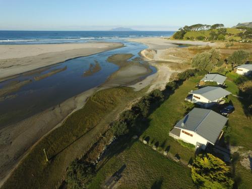 an aerial view of a house and the beach at Pakiri Beach Holiday Park in Pakiri