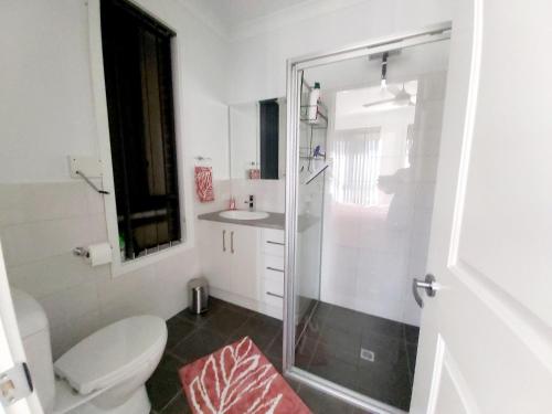 a bathroom with a shower and a toilet and a sink at Lovely Modern 3br 2bth Beachside suburb Home in Largs