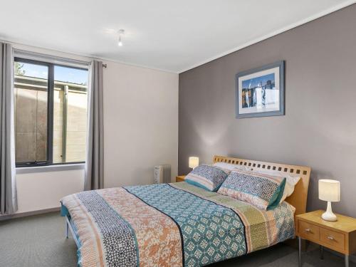 a bedroom with a bed and a window at Apartment 29 Pacific Apartments in Lorne