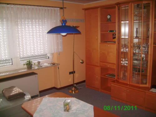 a living room with a table and a blue lamp at Ferienwohnung Hau in Kradenbach