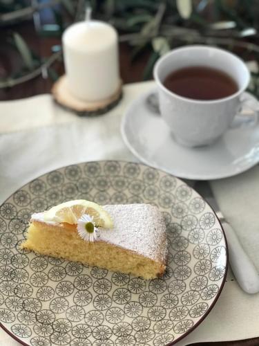 a piece of cake on a plate next to a cup of tea at Ti vengo a cercare B&B in Castellaro