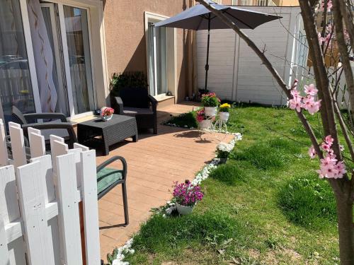 a patio with an umbrella and a table and chairs at Casa Bella in Ştefăneştii de Jos