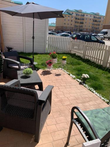 a patio with an umbrella and a table and chairs at Casa Bella in Ştefăneştii de Jos