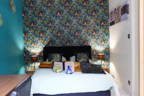 Un dormitorio con una cama con papel pintado floral. en Le gîte des sources: nature, randonnées, détente., en Oberbronn