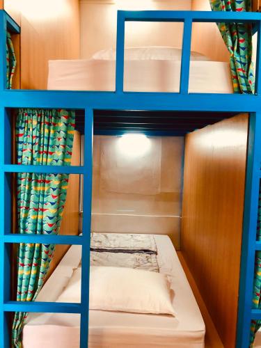 a room with a bunk bed with blue shelves at DoDoWu Homestay in Lanyu
