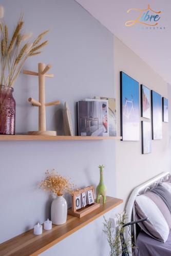 a shelf on a wall with a cross and pictures at Libré Homestay in Hanoi