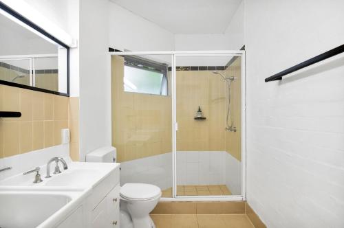 a bathroom with a shower and a toilet and a sink at Noosa Views in Noosa Heads