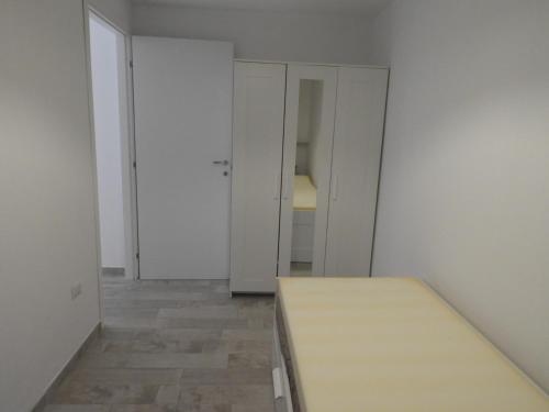 una camera con pareti bianche e un tavolo in legno di Baby House Calasetta - IUN P5263 a Calasetta