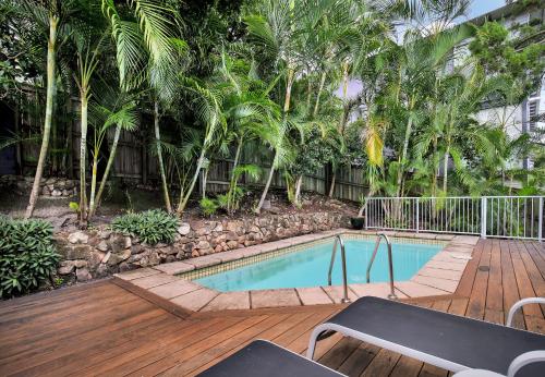 a pool on a wooden deck with palm trees at Noosa Views in Noosa Heads