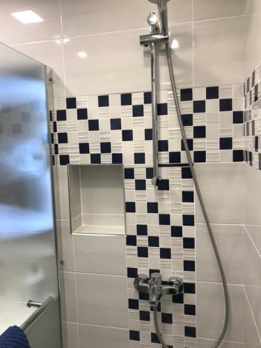 a shower with a black and white checkered tile at Familienapartment am Strand in Primorsko in Primorsko