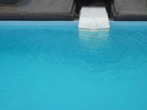a white bed in a pool of blue water at Residence Japoma in Douala