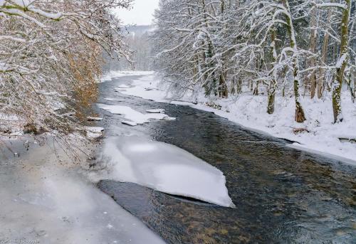 a river with snow on the side of it at Ferienwohnung am Ilztal in Hutthurm