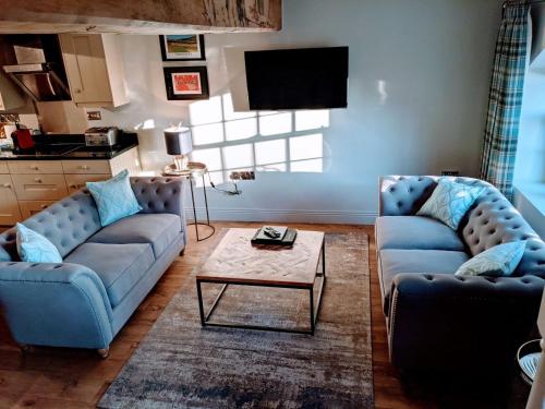 a living room with two couches and a coffee table at The Saddle Room in Middleham