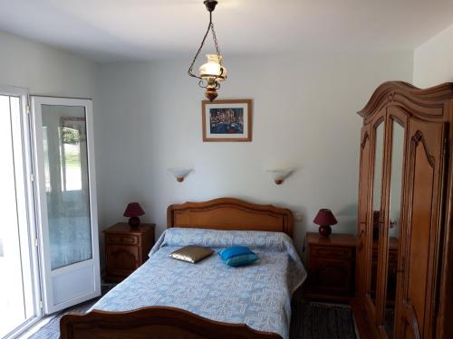 Un dormitorio con una cama con almohadas azules. en Appartement en rez de chaussee de maison en Espelette