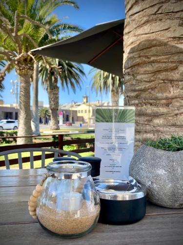a table with a glass jar and a bowl of sand at Atlantic Garden Boutique Hotel in Swakopmund