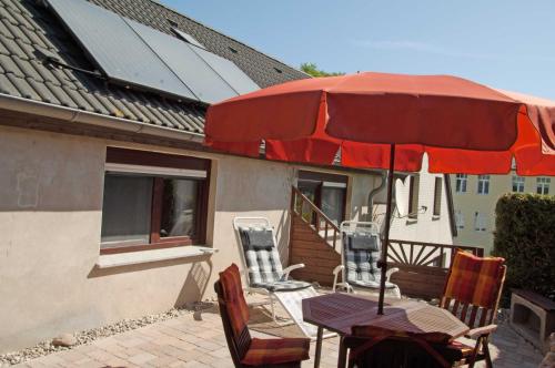 un patio avec une table, des chaises et un parasol dans l'établissement Ferienwohnung Hanna, à Sellin