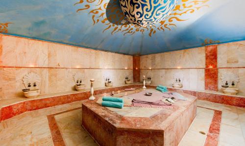 a bathroom with a large tub with a fancy ceiling at Miarosa Kemer Beach in Kemer