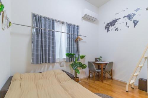 a bedroom with a bed and a table and a world map on the wall at japan house Ikebukuro in Tokyo