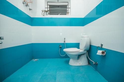 a blue and white bathroom with a toilet at Hidden Heaven in Coonoor