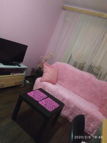 ヨシュカル・オラにあるKOMFORT около набережнойのリビングルーム(ピンクのソファ、テーブル付)
