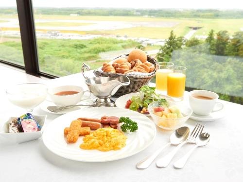 a breakfast table with a plate of breakfast foods and drinks at Marroad International Hotel Narita in Narita