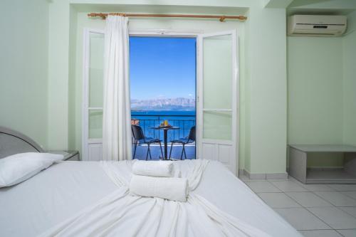 a bedroom with a bed with a view of the ocean at Ionian Melody in Nikiana